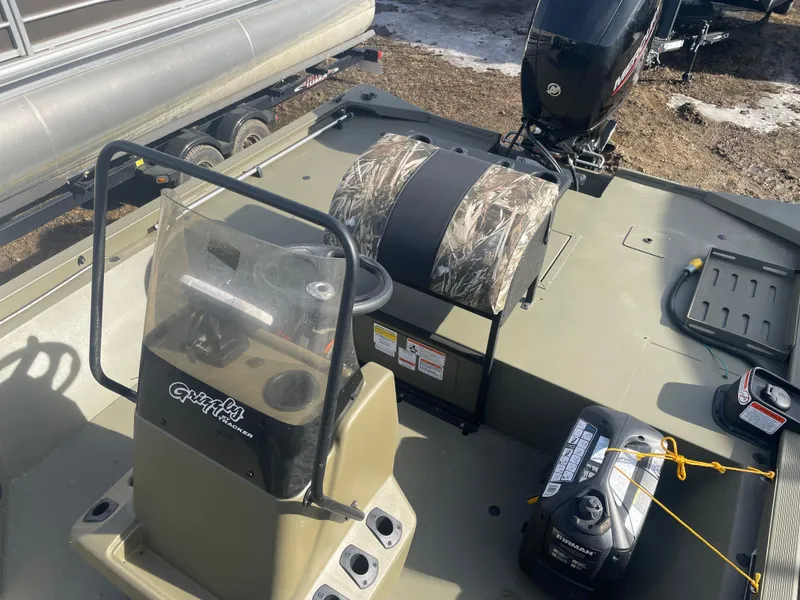 Slide: The Image of 2024 Tracker Grizzly 2072 CC Sportsman boat interior with console and motor. - 14