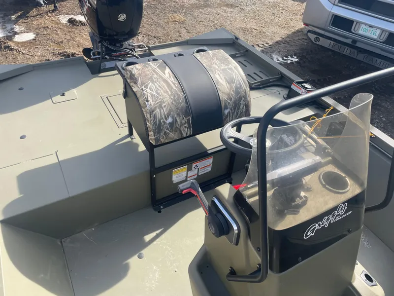 Slide: The Image of 2024 Tracker Grizzly 2072 CC Sportsman boat interior with camo seat and steering console. - 8