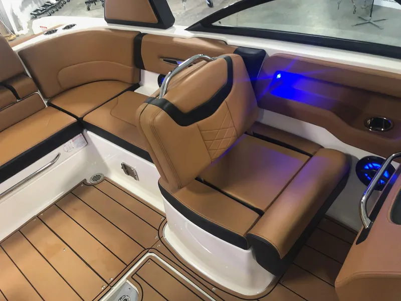 Slide: The Image of 2024 Chaparral 247 SSX boat interior with tan leather seats and blue LED lighting. - 10