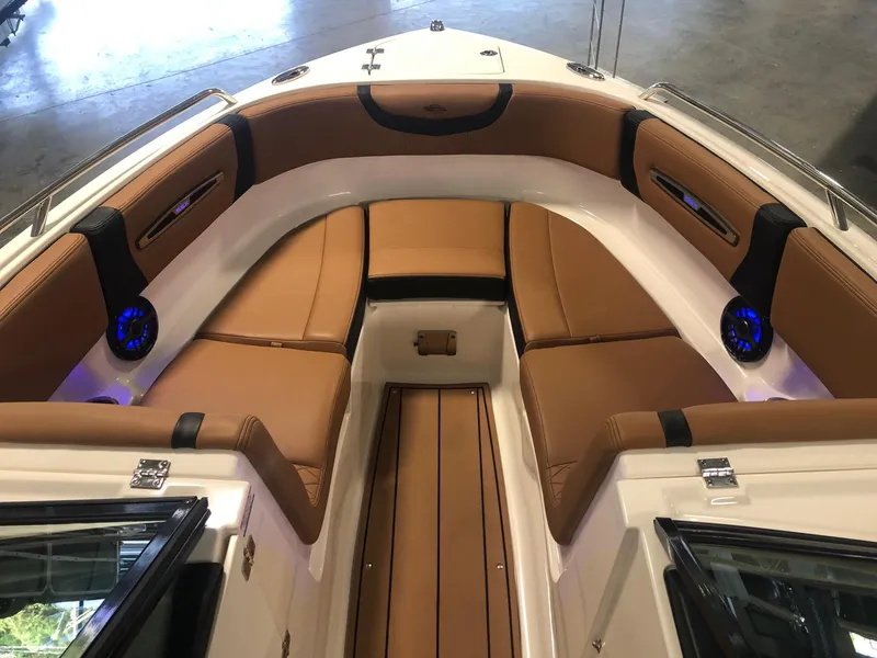 Slide: The Image of 2024 Chaparral 247 SSX boat interior with tan leather seating and blue LED speakers. - 14