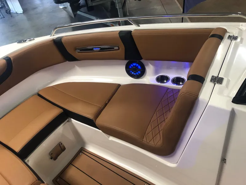 Slide: The Image of 2024 Chaparral 247 SSX boat interior with tan leather seating and blue LED lighting. - 15