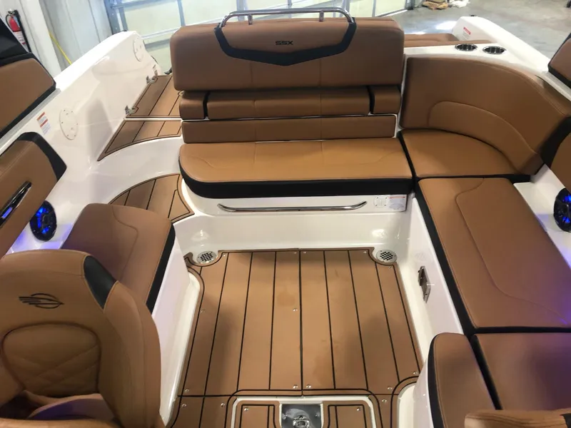 Slide: The Image of 2024 Chaparral 247 SSX boat interior with brown leather seating and teak flooring. - 17
