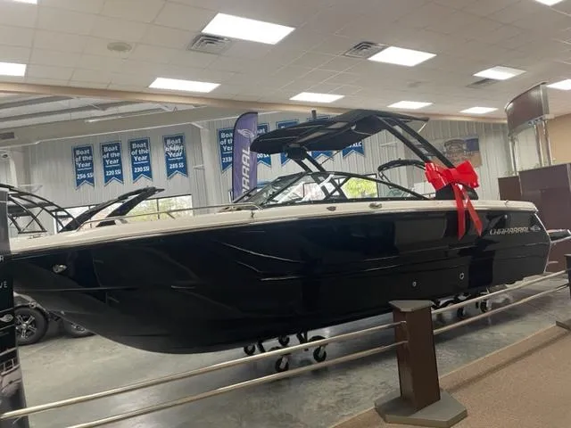 Slide: The Image of 2024 Chaparral 247 SSX boat on display with a red bow in a showroom. - 2