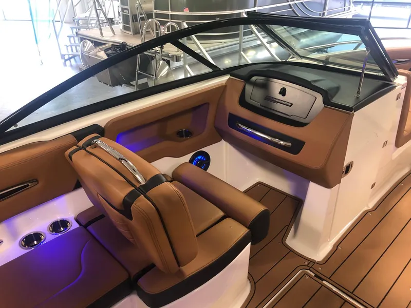 Slide: The Image of 2024 Chaparral 247 SSX boat interior with tan leather seats and modern dashboard. - 8