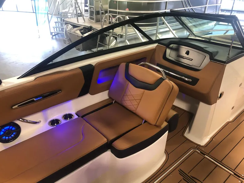 Slide: The Image of 2024 Chaparral 247 SSX boat interior with tan leather seats and blue LED lighting. - 9