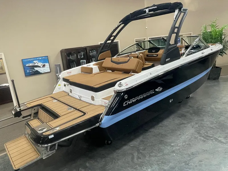 The Image of 2024 Chaparral 247 SSX boat in showroom, black hull, tan interior, swim platform. - 0