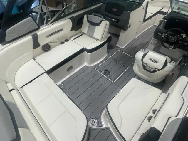 Slide: The Image of 2024 Chaparral 247 SSX boat interior with white and gray seating and modern dashboard. - 4