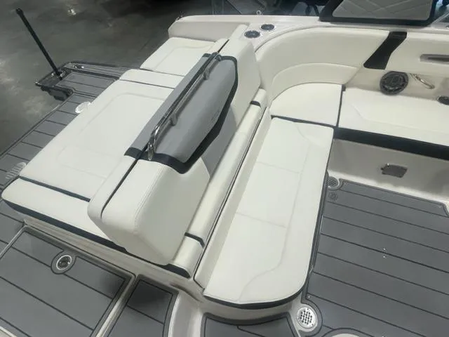 Slide: The Image of 2024 Chaparral 247 SSX boat interior with white seating and gray flooring. - 6