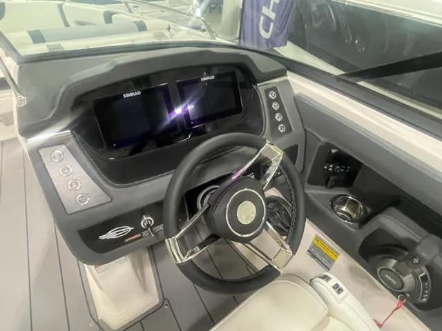 Slide: The Image of 2024 Chaparral 247 SSX boat dashboard with dual Simrad displays and steering wheel. - 9