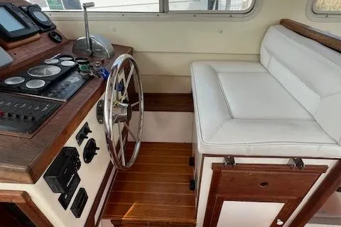 Slide: The Image of 1989 Blue Seas Flybridge Cruiser helm with wooden accents and white cushioned seating. - 10