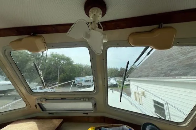 Slide: The Image of Interior view of 1989 Blue Seas Flybridge Cruiser with large windows and ceiling fan. - 12