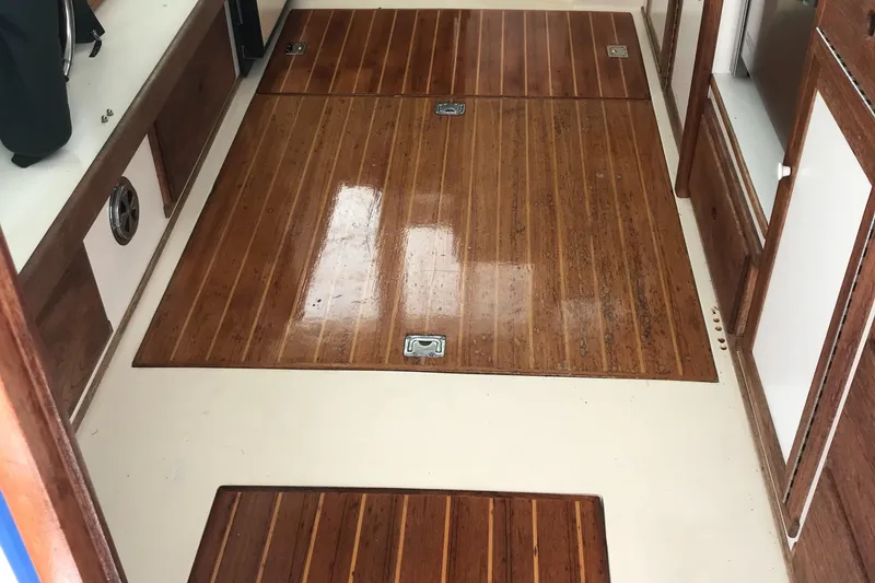 Slide: The Image of 1989 Blue Seas Flybridge Cruiser interior with polished wooden flooring. - 13