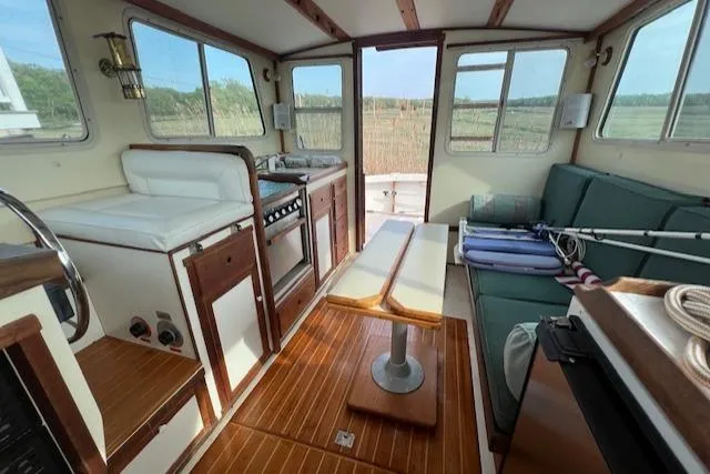 Slide: The Image of Interior of 1989 Blue Seas Flybridge Cruiser with seating, kitchen, and wooden flooring. - 2