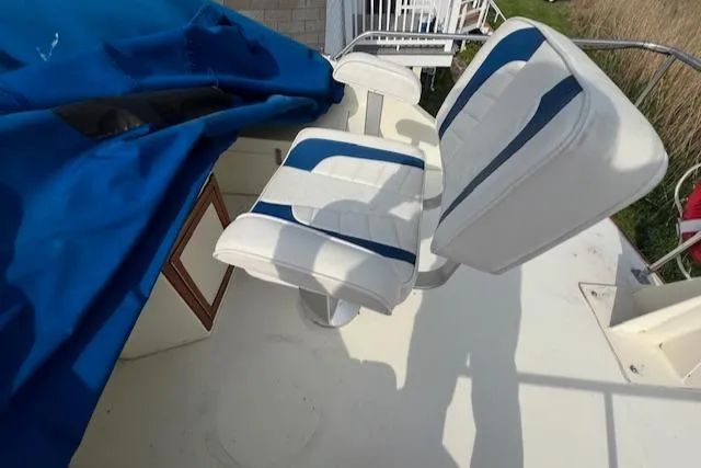 Slide: The Image of 1989 Blue Seas Flybridge Cruiser with white and blue seating, partially covered by a blue tarp. - 28