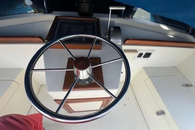 Slide: The Image of Steering wheel of 1989 Blue Seas Flybridge Cruiser with wooden accents and control panel. - 29