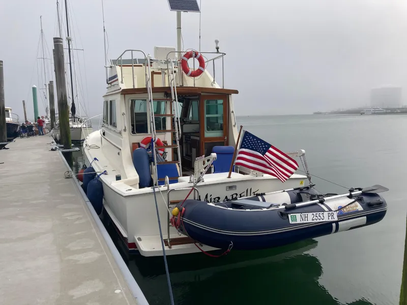Slide: The Image of 1989 Blue Seas Flybridge Cruiser docked with American flag and dinghy. - 37