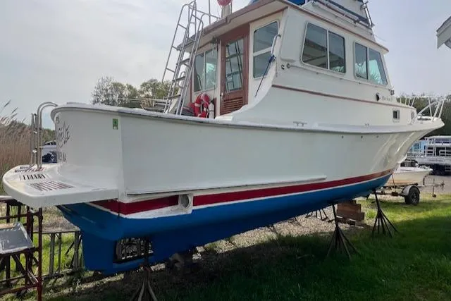 Slide: The Image of 1989 Blue Seas Flybridge Cruiser on stands, white hull with red and blue accents. - 46
