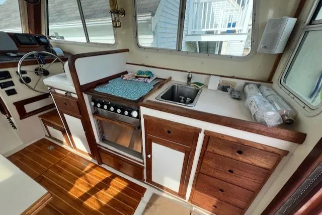 Slide: The Image of 1989 Blue Seas Flybridge Cruiser interior with wooden cabinetry and kitchen amenities. - 7