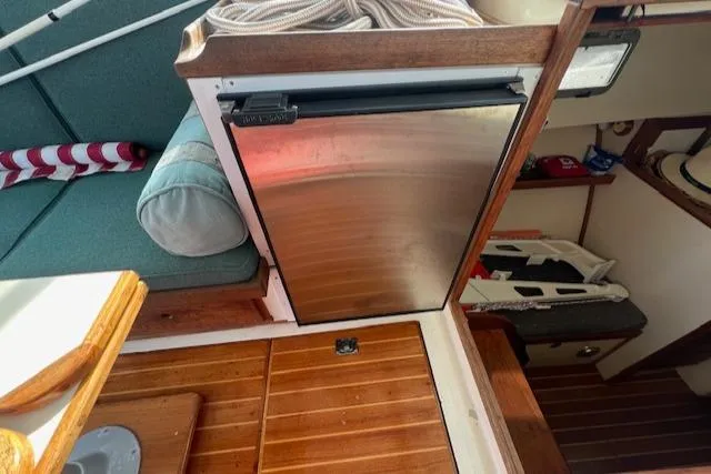 Slide: The Image of Interior of 1989 Blue Seas Flybridge Cruiser with stainless steel fridge and wooden flooring. - 8