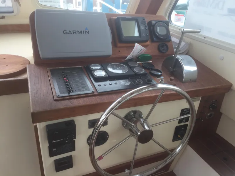 Slide: The Image of 1989 Blue Seas Flybridge Cruiser helm with Garmin navigation and control instruments. - 9