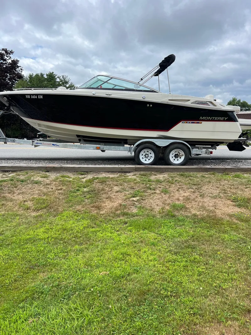 Slide: The Image of 2014 Monterey 268 boat on trailer, parked outdoors under cloudy sky. - 3