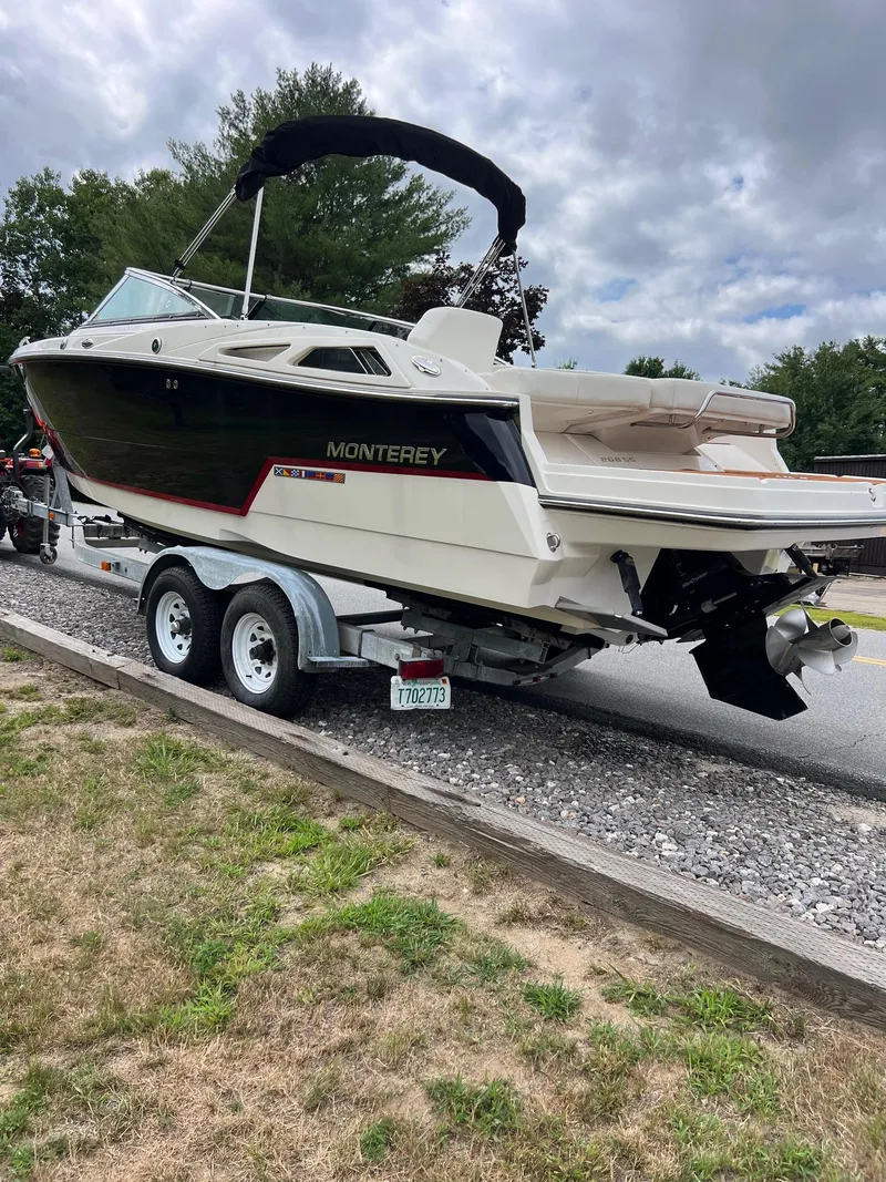 Slide: The Image of 2014 Monterey 268 boat on trailer, parked outdoors under cloudy sky. - 5