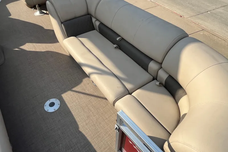 Slide: The Image of 2024 Sun Tracker Party Barge 24 DLX interior with beige seating and carpeted floor. - 5