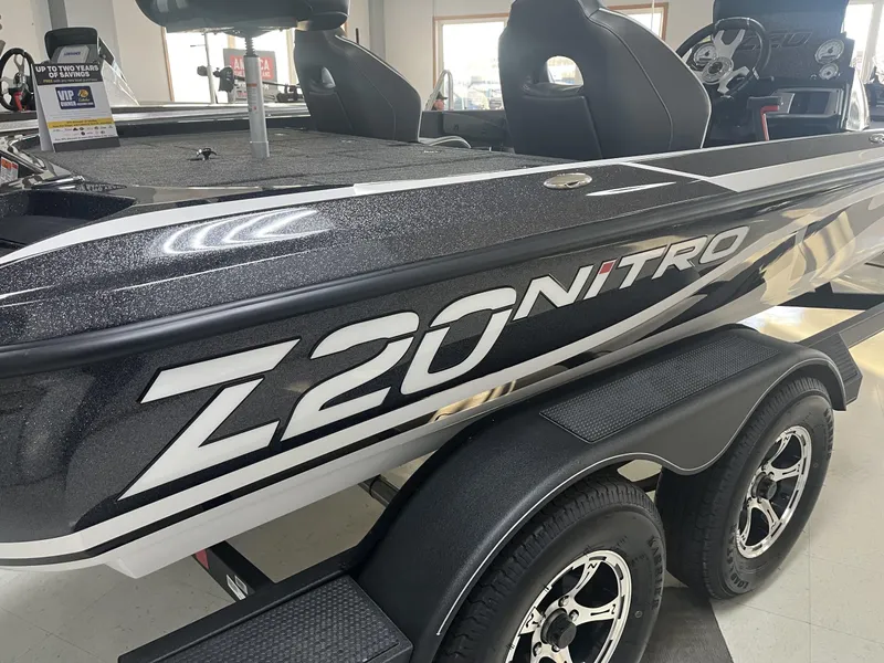 Slide: The Image of 2024 Nitro Z20 boat with sleek design and dual axle trailer in showroom. - 1