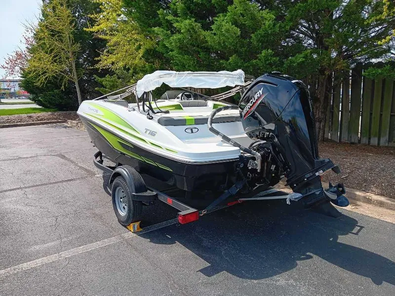 Slide: The Image of 2024 Tahoe T16 boat on trailer, parked outdoors, featuring a Mercury outboard motor. - 10