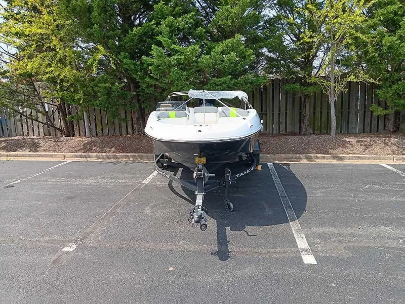 Slide: The Image of 2024 Tahoe T16 boat parked in a lot, surrounded by trees. - 8