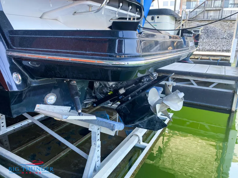 Slide: The Image of 2021 Monterey 278SS boat on a lift at a marina, showing the stern and propeller. - 14