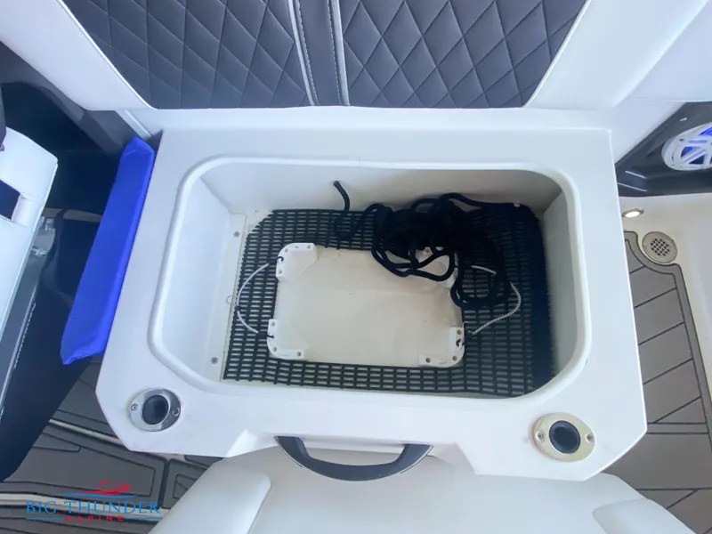 Slide: The Image of 2021 Monterey 278SS boat storage compartment with black netting and cup holders. - 23