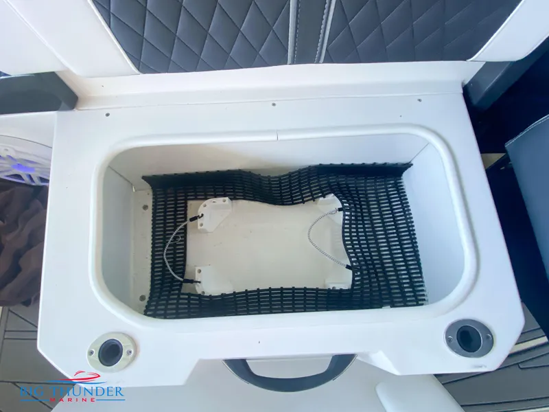 Slide: The Image of 2021 Monterey 278SS boat storage compartment with black netting and cup holders. - 25