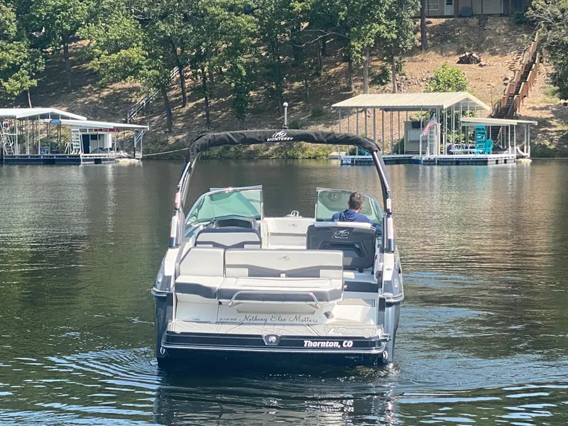 Slide: The Image of Monterey 278SS boat on a calm lake, surrounded by trees and docks, 2021 model. - 8