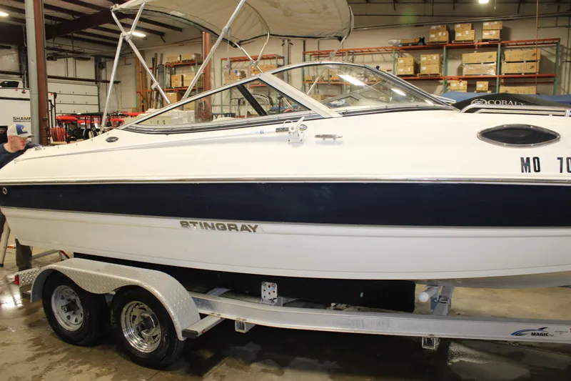 Slide: The Image of 2013 Stingray 208 CK boat on a trailer in a warehouse. - 10