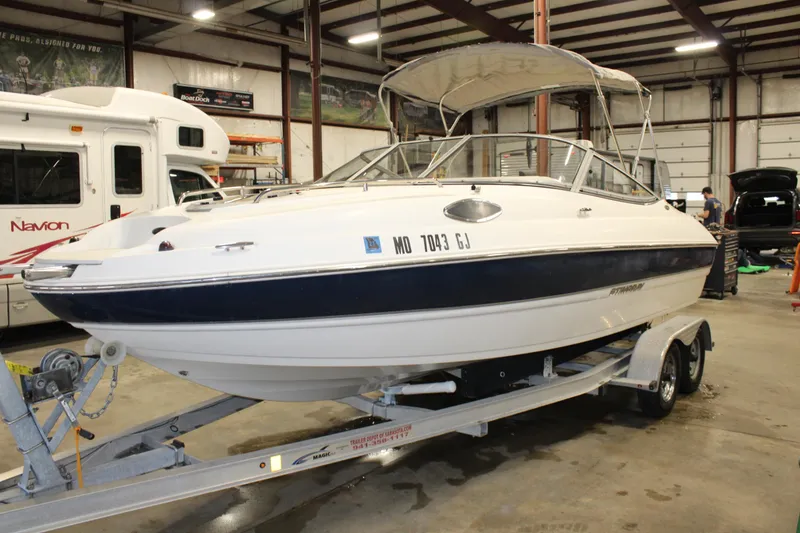 Slide: The Image of 2013 Stingray 208 CK boat on trailer in indoor storage facility. - 13