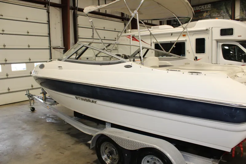 Slide: The Image of 2013 Stingray 208 CK boat on trailer in indoor storage facility. - 15