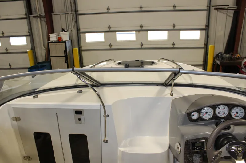 Slide: The Image of 2013 Stingray 208 CK boat interior with dashboard and controls in a garage. - 17
