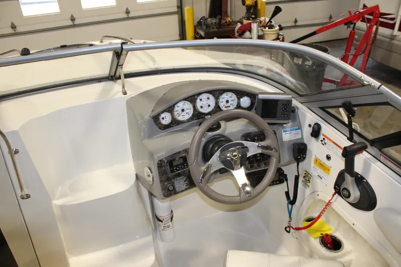 Slide: The Image of 2013 Stingray 208 CK boat dashboard with steering wheel and control panel. - 18