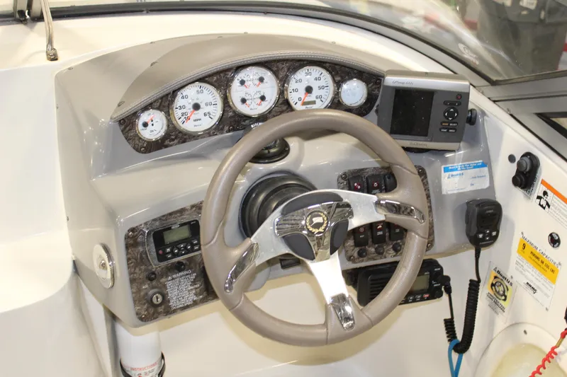 Slide: The Image of 2013 Stingray 208 CK boat dashboard with steering wheel, gauges, and navigation equipment. - 20