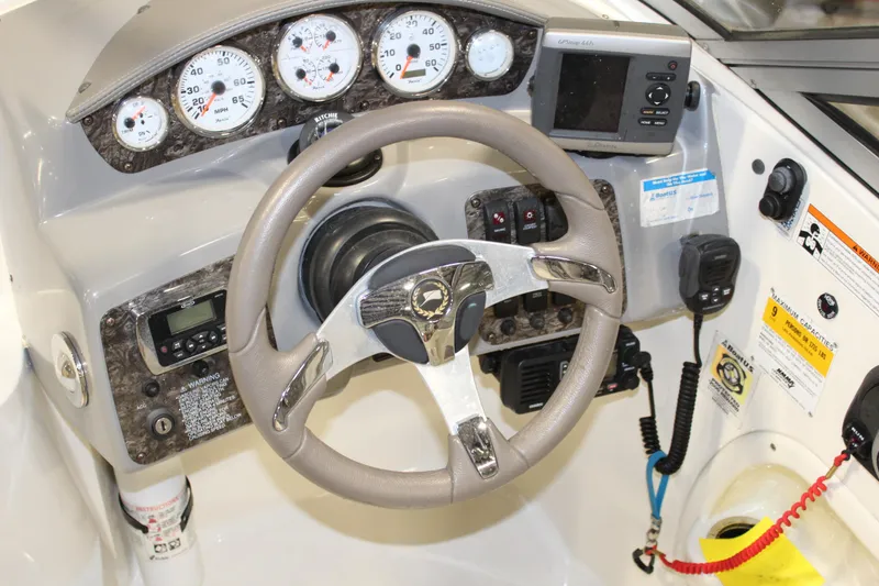 Slide: The Image of 2013 Stingray 208 CK boat dashboard with steering wheel, gauges, and navigation equipment. - 22