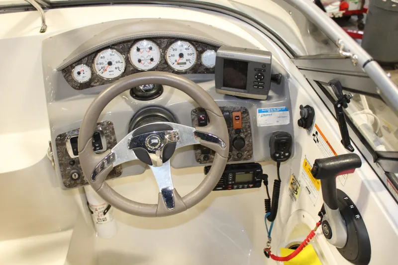 Slide: The Image of Stingray 208 CK 2013 boat dashboard with steering wheel, gauges, and navigation equipment. - 25