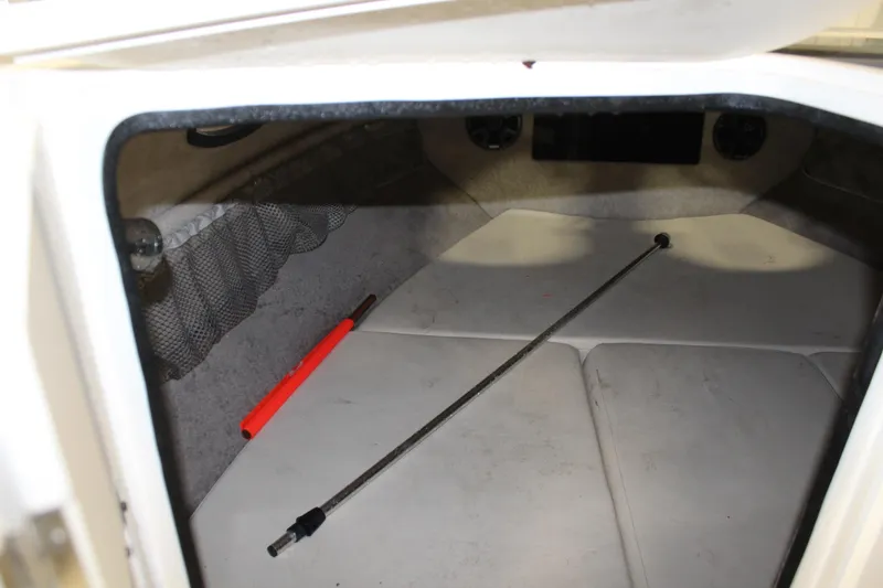 Slide: The Image of Interior cabin of a 2013 Stingray 208 CK boat with storage net and rod. - 28