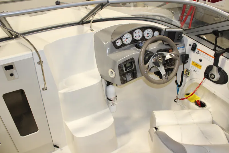 Slide: The Image of 2013 Stingray 208 CK boat cockpit with steering wheel, gauges, and seating. - 34