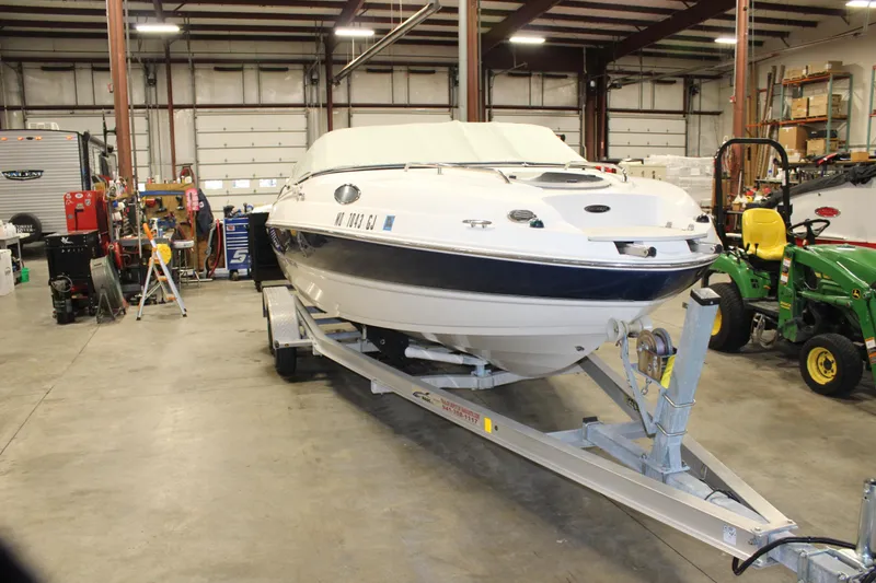 Slide: The Image of 2013 Stingray 208 CK boat on trailer in a spacious indoor garage. - 41