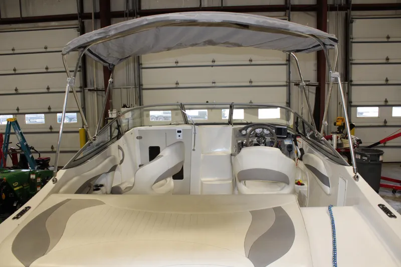 Slide: The Image of 2013 Stingray 208 CK boat interior with canopy in a garage. - 6