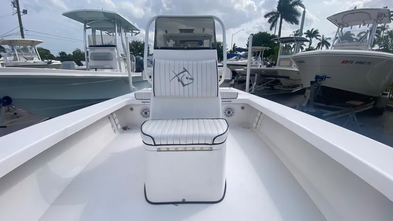 Slide: The Image of 2025 Piranha F2000 boat interior with white seating, docked among other boats. - 2