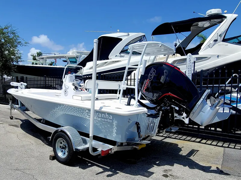 Slide: The Image of 2025 Piranha F2000 boat on trailer, parked near other boats, sunny day. - 20