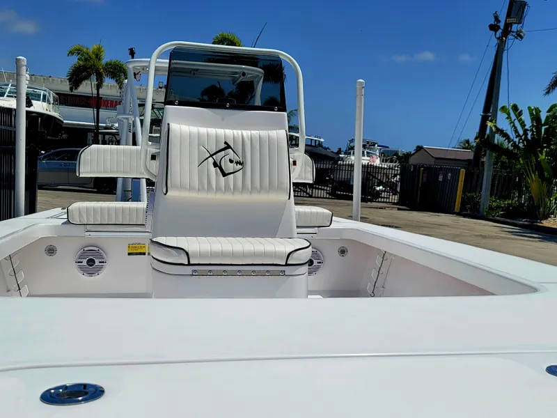 Slide: The Image of 2025 Piranha F2000 boat interior with white seating and console, docked under clear blue sky. - 23