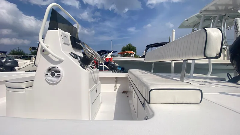 Slide: The Image of 2025 Piranha F2000 boat interior with white seating and control panel under a blue sky. - 3